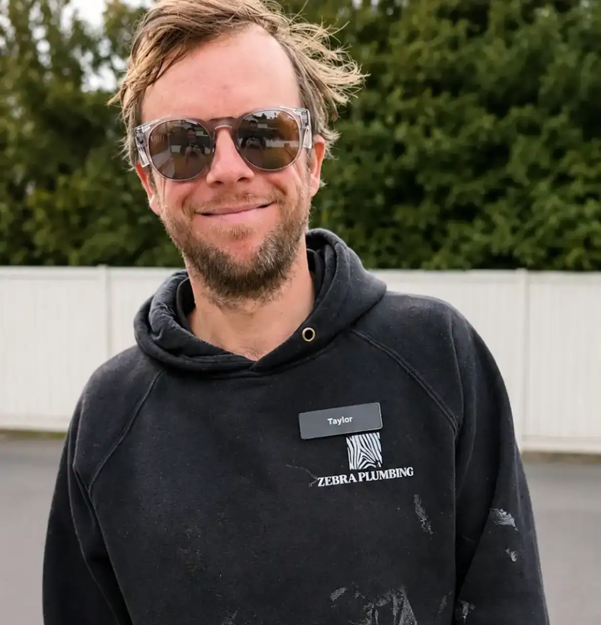 Zebra Plumbing technician wearing a black hoodie with Zebra Plumbing logo and name tag.