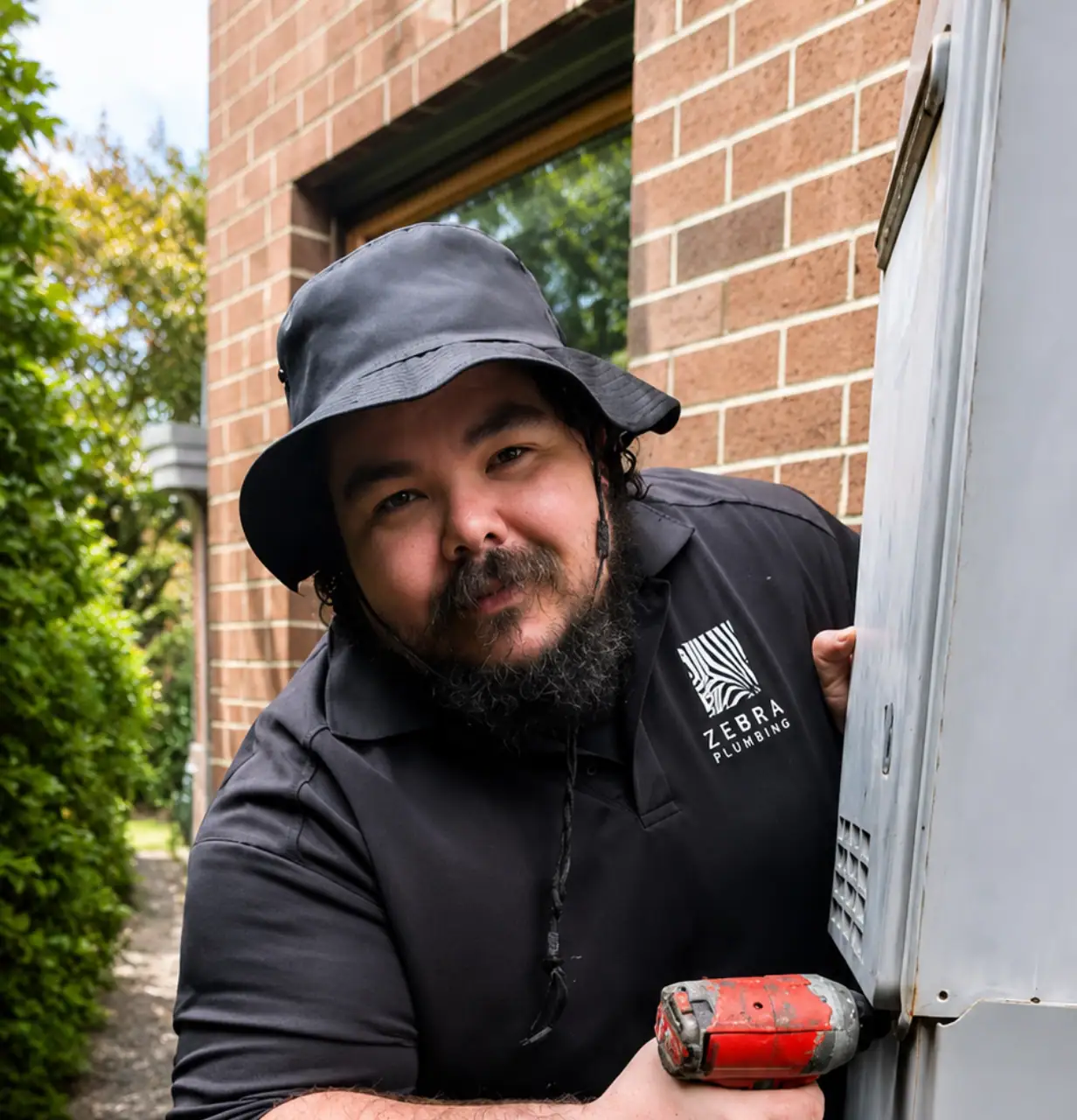 Jayden, Dispatch & Plumber Support at Zebra Plumbing, working on a residential hot water system.