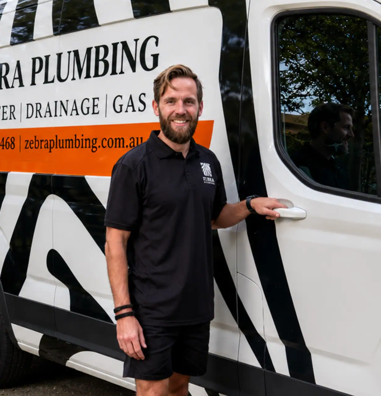 Gary, Sales & Team Lead at Zebra Plumbing, standing beside a branded Zebra Plumbing van in Melbourne.